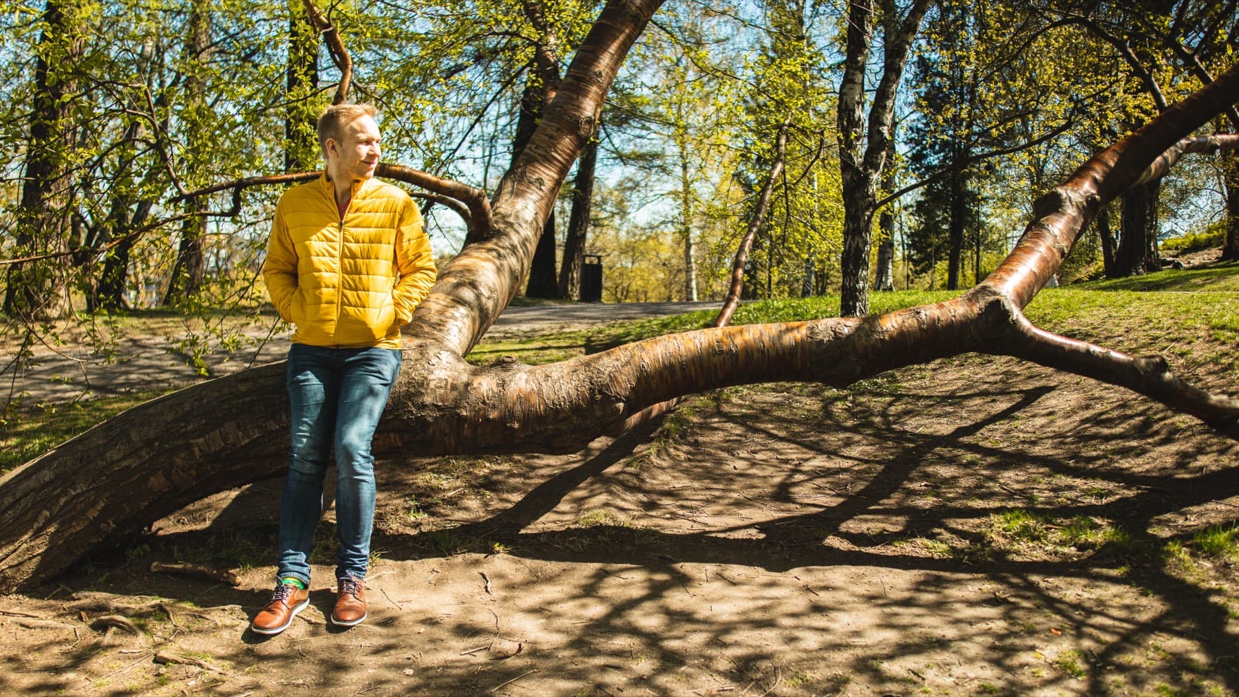 Jaakko keltaisessa takissa nojaa kaatuneeseen puuhun Näsijärven rannassa Tampereella